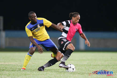 Photo: Defence Force striker Devorn Jorsling (left) chases Central FC midfielder Nathaniel Garcia during the Digicel Charity Shield on 10 September 2016. (Courtesy Chevaughn Christopher/Wired868)