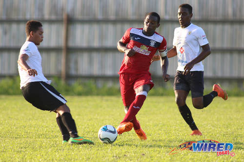 Photo: Fyzabad Secondary Sharkeel Louison (centre) passes the ball during SSFL Premier Division action against St Anthony's College on 24 September 2016 at Fyzabad. (Courtesy Chevaughn Christopher/Wired868)