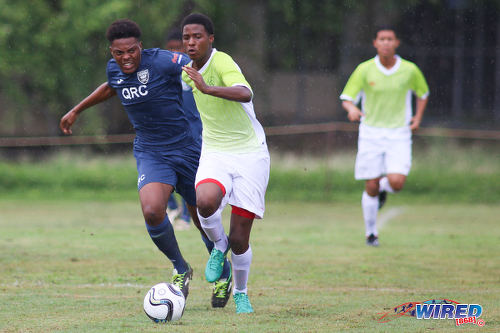 Photo: St Augustine Secondary captain Anthony Samuel (right) tries to escape from QRC defender Tevin Lessey during SSFL Premier Division action at the QRC grounds on 8 September 2016. (Courtesy Chevaughn Christopher/Wired868)