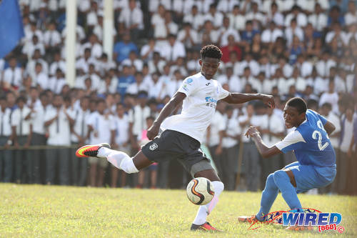 Photo: Naparima College forward Isaiah Lee (left) takes his aim while Presentation College (San Fernando) midfielder Kori Cupid looks on during SSFL Premier Division action at Lewis Street, San Fernando on 28 September 2016. Lee scored one and set up another as Naparima won 2-0. (Courtesy Allan V Crane/Wired868)