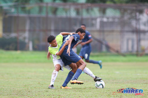 Photo: QRC midfielder Kalev Keil (right) is tackled by a St Augustine player during SSFL Premier Division action at the QRC grounds on 8 September 2016. (Courtesy Chevaughn Christopher/Wired868)