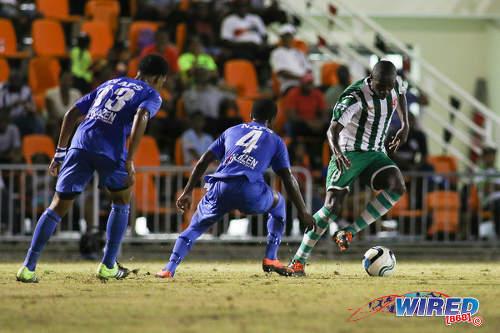 Photo: San Juan North Secondary forward Renaldo Boyce (right) runs at Naparima College players Aalon Minors (centre) and Jeron Pantor during SSFL Premier Division action at Irwin Park, Siparia on 7 September 2016. Both teams played to a 2-2 draw. (Courtesy Chevaughn Christopher/Wired868)