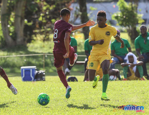 Photo: Signal Hill Secondary captain Akil Frank (right) slips the ball past East Mucurapo player Joshua Constantine during SSFL Premier Division action at Moka on 14 September 2016. (Courtesy Sean Morrison/Wired868)