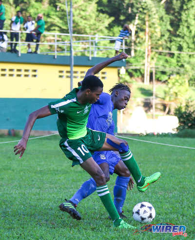 Photo: Trinity College Moka forward Isaiah McLean (left) tries to escape from Naparima College left back Khris Stroud during SSFL Premier Division action on 21 September 2016 at Moka. (Courtesy Sean Morrison/Wired868)