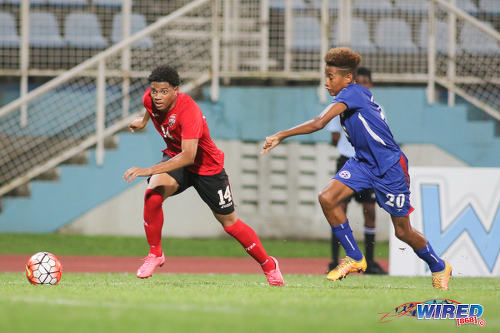 Photo: Trinidad and Tobago National Under-17 midfielder Kishon Hackshaw (left) races away from Bermuda full back Richard Jones during 2017 World Cup qualifying action at the Ato Boldon Stadium on 18 September 2016. (Courtesy Chevaughn Christopher/Wired868)