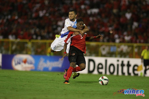 Photo: Hugs for Joevin Jones. Guatemala defender Christian Jimenez (left) tugs back Jones during Russia 2018 World Cup qualifying action at the Hasely Crawford Stadium, Port of Spain on 2 September 2016. Jimenez was sent off for the foul while Jones scored twice as the two nations played to a 2-2 draw. (Courtesy Chevaughn Christopher/Wired868)