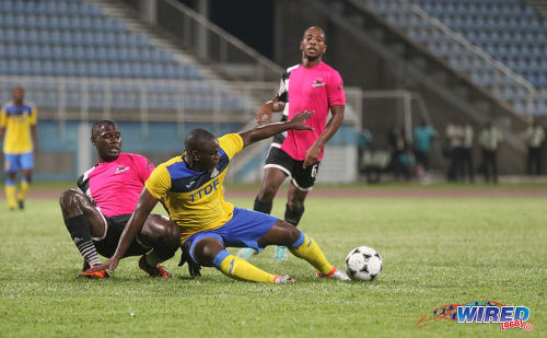 Photo: Defence Force striker Devorn Jorsling (centre) keeps his eye on the ball while Central FC players Keion Goodridge (left) and Leston Paul look on during Pro League action at the Ato Boldon Stadium in Couva on 14 October 2016. (Courtesy Sean Morrison/Wired868)