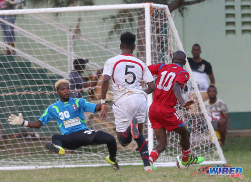 Photo: St Ann's Rangers forward Devon Modeste (right) shoots wide under pressure by Morvant Caledonia United goalkeeper Stephon Seepersad (left) and defender Seon Thomas during Pro League action at the Barataria Recreation Ground on 9 October 2016. (Courtesy Sean Morrison/Wired868)