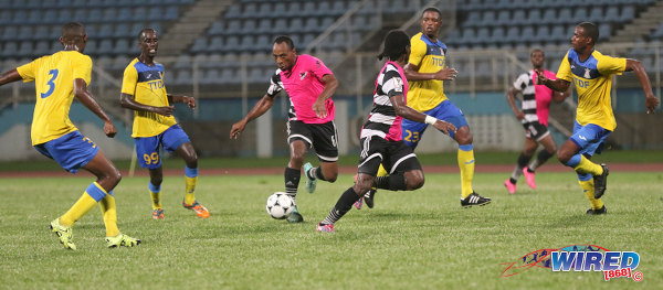 Photo: Central FC midfielder Leston Paul (centre) tries to find through a packed Defence Force rearguard during Pro League action at the Ato Boldon Stadium in Couva on 14 October 2016. (Courtesy Sean Morrison/Wired868)