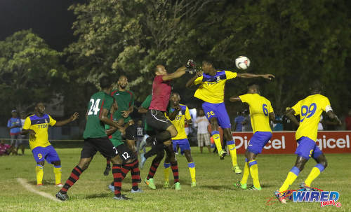 Photo: San Juan Jabloteh goalkeeper Shemel Louison (centre) punches away the ball under pressure from Defence Force left back Justin Garcia (third from right) during Pro League action at the Barataria Recreation Ground on 9 October 2016. (Courtesy Sean Morrison/Wired868)