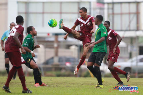 Photo East Mucurapo midfielder Joshua Constantine (centre) shows his studs as he goes for the ball while St Benedict's College midfielder Kristoff Burkett (second from left) has second thoughts during SSFL Premier Division action at Mucurapo Road on 6 October 2016. (Courtesy Nicholas Bhajan/Wired868)