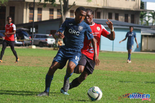 Photo: Queen's Royal College playmaker John-Paul Rochford (left) tries to keep the ball from St Anthony's College winger Haile Beckles during SSFL action at QRC grounds on 26 October 2016. (Courtesy Nicholas Williams/Wired868)