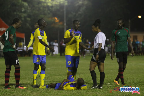 Photo: Defence Force striker Devorn Jorsling (centre) pleads his case to referee Crystal Sobers while teammate Jemel Sebro (lying) awaits the verdict and team captain Jerwyn Balthazar (second from left) pays close attention during Pro League action at the Barataria Recreation Ground on 9 October 2016. Looking on are San Juan Jabloteh players Tyrone Charles (far left) and Keyon Edwards. (Courtesy Sean Morrison/Wired868)