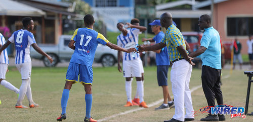 Photo: Shiva Boys Hindu College coach Hayden Ryan (second from right) hands a water bottle to winger Ronaldo Edwards during SSFL Premier Division action against St Mary's College at Lachoo Road on 19 October 2016. (Courtesy Sean Morrison/Wired868)