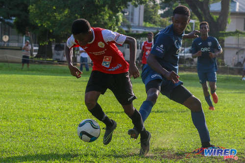 Photo: A St Anthony's College player (left) slips away from a QRC opponent during SSFL action at QRC grounds on 26 October 2016. (Courtesy Nicholas Williams/Wired868)