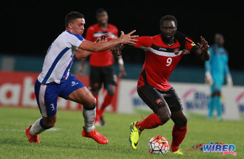 Photo: Trinidad and Tobago captain Kenwyne Jones (right) holds off Dominican Republic defender César Garcia during 2017 Caribbean Cup qualifying action at the Ato Boldon Stadium in Couva on 5 October 2016. (Courtesy Nicholas Bhajan/Wired868)