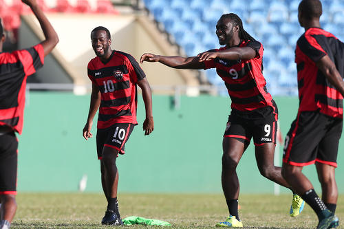 Photo: Trinidad and Tobago National Senior Team captain Kenwyne Jones (second from right) shares a light moment with teammate Kevin Molino (second from left) during a national training session. (Courtesy KJ Media)