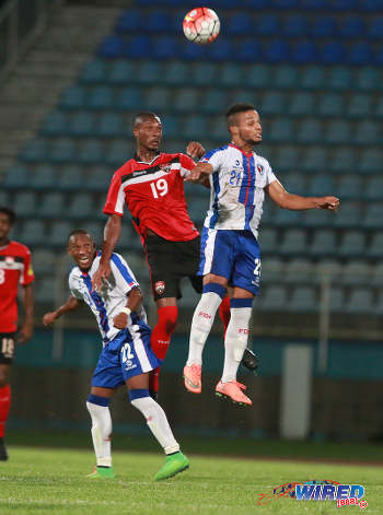 Photo: Trinidad and Tobago defensive midfielder Kevan George (centre) challenges Dominican Republic midfielder Rafael Flores (right) in the air during 2017 Caribbean Cup qualifying action at the Ato Boldon Stadium in Couva on 5 October 2016. (Courtesy Nicholas Bhajan/Wired868)