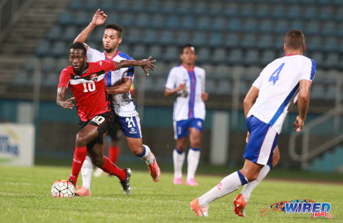 Photo: Trinidad and Tobago attacker Kevin Molino (left) tries to escape from Dominican Republic midfielder Rafael Flores during 2017 Caribbean Cup qualifying action at the Ato Boldon Stadium in Couva on 5 October 2016. (Courtesy Nicholas Bhajan/Wired868)