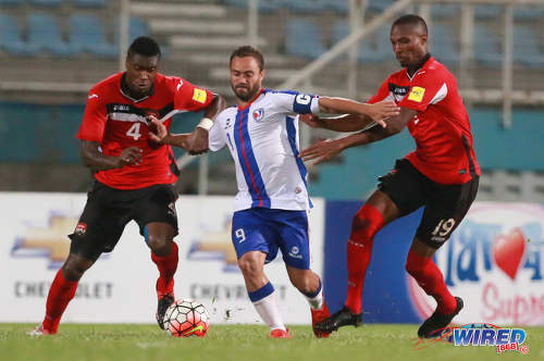 Photo: Dominican Republic captain Jonathan Faña (centre) tries to hold off Trinidad and Tobago players Sheldon Bateau (left) and Kevan George during 2017 Caribbean Cup qualifying action at the Ato Boldon Stadium in Couva on 5 October 2016. (Courtesy Nicholas Bhajan/Wired868)