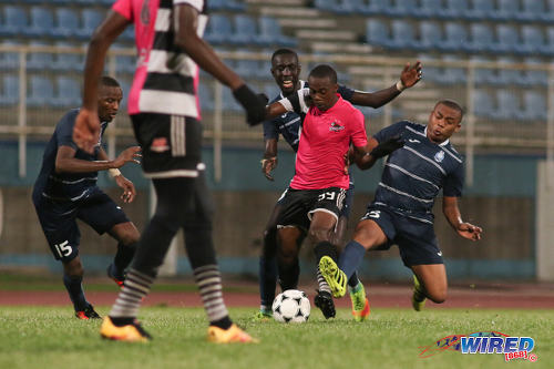 Photo: Central FC attacker Marcus "Lobo" Joseph (centre) is harassed by Police FC midfielders Kenaz Williams (right) and Kurdell Brathwaite (background) during Pro League action at the Ato Boldon Stadium on 4 November 2016. (Courtesy Chevaughn Christopher/Wired868)