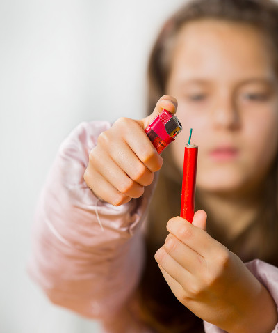 Photo: A child lights a firecracker.