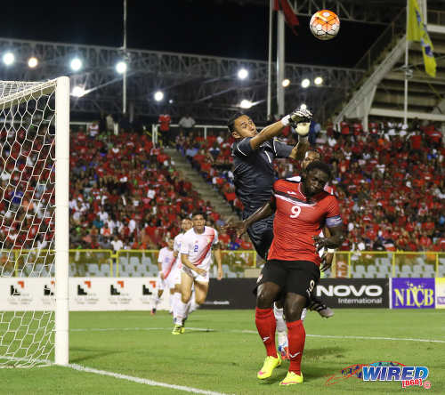 Photo: Costa Rica goalkeeper Keylor Navas (top) punches the ball away from Trinidad and Tobago forward Kenwyne Jones during Russia 2018 World Cup qualifying action at the Hasely Crawford Stadium on 11 November 2016. (Courtesy Sean Morrison/Wired868)