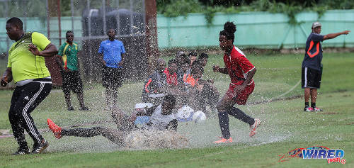 Photo: Malick Secondary coach Anthony Bartholomew (far left) takes evasive action after Trinity College East midfielder Marli Greaves (centre) lunged in to tackle opponent Tyrique Reid during Championship Big 5 Play Off action in Trincity on 6 November 2016. (Courtesy Sean Morrison/Wired868)