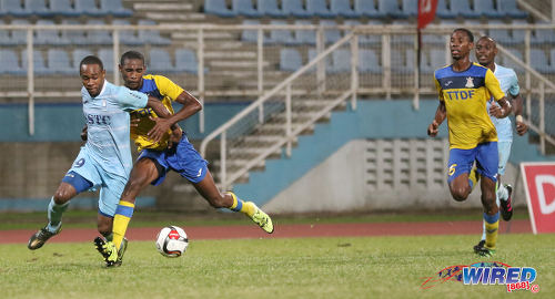 Photo: Police FC attacker Christon Thomas (left) tries to elude Defence Force defender Jamali Garcia (centre) while his teammate Rodell Elcock looks on during Pro League at the Ato Boldon Stadium in Couva on 22 November 2016. (Courtesy Sean Morrison/Wired868)