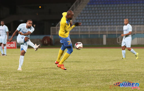 Photo: Police FC right back Jibri McDavid (left) shoots for goal while Defence Force left back Akile Edwards takes evasive action during Pro League at the Ato Boldon Stadium in Couva on 22 November 2016. (Courtesy Sean Morrison/Wired868)