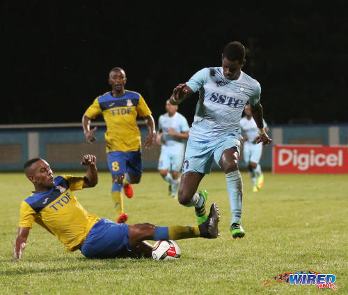 Photo: Police FC attacking midfielder Kareem Freitas (right) tries to get past Defence Force player Curtis Gonzales (left) during Pro League at the Ato Boldon Stadium in Couva on 22 November 2016. (Courtesy Sean Morrison/Wired868)