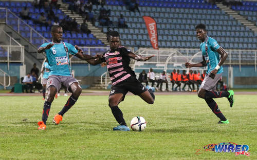 Photo: Ma Pau Stars striker Jerrel Britto (centre) lines up a shot while Morvant Caledonia United defenders Taje Commissiong (left) and Ordell Flemming look on during Pro League at the Ato Boldon Stadium in Couva on 22 November 2016. (Courtesy Sean Morrison/Wired868)