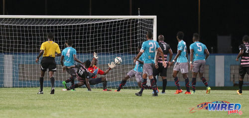 Photo: Ma Pau Stars striker Jerrel Britto (centre) squeezes his shot past Morvant Morvant Caledonia United goalkeeper Marvin Phillip for the decisive goal during Pro League at the Ato Boldon Stadium in Couva on 22 November 2016. (Courtesy Sean Morrison/Wired868)