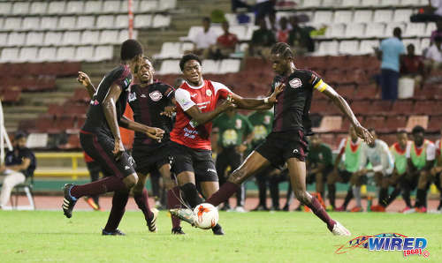 Photo: St Anthony's College attacker Kathon St Hillaire (centre) takes on East Mucurapo Secondary captain Aquinde Marslin and his defence during the North Zone Intercol semifinal at the Hasely Crawford Stadium on 16 November 2016. (Copyright Sean Morrison/Wired868)