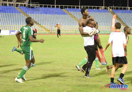 Photo: Trinity College (Moka) goalkeeper Caleb Moore (second from right) is lifted bodily by a member of his coaching staff after helping his school to victory over St Anthony's College in the North Zone Intercol final at the Hasely Crawford Stadium on 25 November 2016. (Courtesy Wired868)