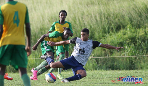 Photo: A Trinity College East player (right) tries to get a shot off under pressure from a Princes Town West Secondary opponent during SSFL Championship Big 5 Play Off action in Princes Town on 4 November 2016. (Courtesy Sean Morrison/Wired868)