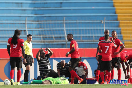 Photo: Trinidad and Tobago National Senior Team medic Dr Terence Babwah (centre) signals for a change while goalkeeper Jan-Michael Williams lays unconscious during 2018 World Cup qualifying action against Honduras in San Pedro Sula on 15 November 2016. (Courtesy Allan V Crane/Wired868)