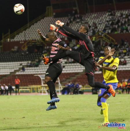 Photo: Defence Force goalkeeper Andre Marchan (centre) punches the ball away from Ma Pau Stars forward Jason Scotland (left) during the First Citizens Bank Cup final at the Hasely Crawford Stadium on 2 December 2016. (Courtesy Sean Morrison/Wired868)