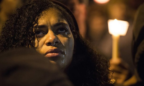 Photo: A Baltimore resident takes part in a candlelight vigil for Freddie Gray, who was killed by the police. (Copyright Guardian UK)