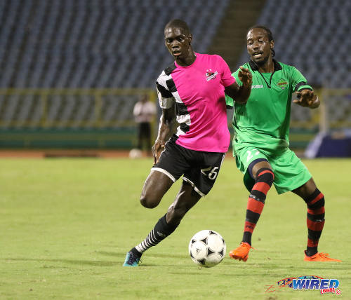 Photo: Central FC goal scorer Jem Gordon (left) tries to escape from San Juan Jabloteh winger Nathan Lewis during Pro League action at the Hasely Crawford Stadium on 2 December 2016. (Courtesy Sean Morrison/Wired868)