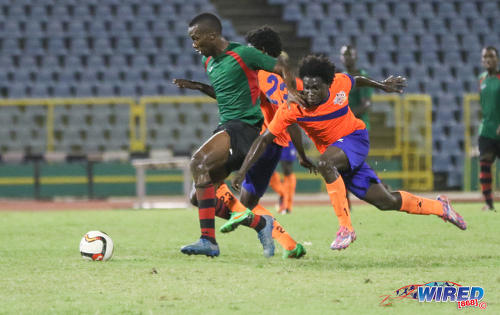 Photo: San Juan Jabloteh forward Jamal Gay (centre) holds off a Club Sando defender during Pro League action at the Hasely Crawford Stadium on 9 December 2016. (Courtesy Sean Morrison/Wired868)