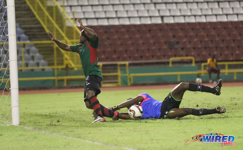 Photo: San Juan Jabloteh attacker Kennedy Hinkson (left) trips over Club Sando goalkeeper Kelvin Henry and is about to clatter into the upright during Pro League action at the Hasely Crawford Stadium on 9 December 2016. (Courtesy Sean Morrison/Wired868)