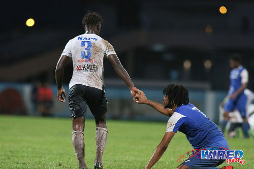 Photo: Naparima College left back Khris Stroud (left) offers a hand to Presentation College (San Fernando) attacker Nion Lammy after the Big Four final at the Ato Boldon Stadium, Couva on 12 December 2016. (Courtesy Chevaughn Christopher/Wired868)