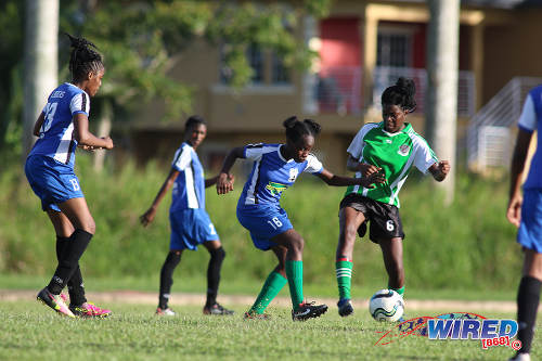 Photo: A Fyzabad Anglican Secondary player (centre) tries to play the ball around Penal Secondary player Elise Simone during the Girls South Zone Knockout final at the Mannie Ramjohn Stadium training ground on 2 December 2016. (Courtesy Chevaughn Christopher/Wired868)