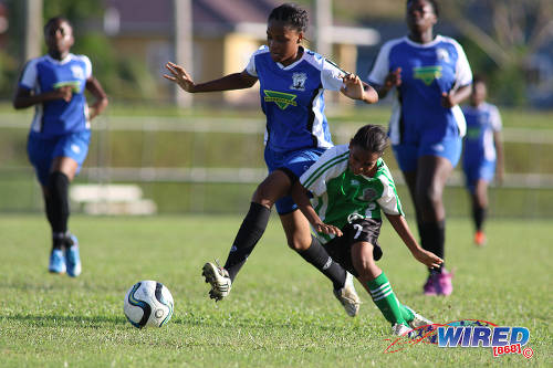 Photo: Penal Secondary attacker Petrice Tyson (right) tumbles under a challenge from a Fyzabad Anglican Secondary player during the Girls South Zone Knockout final at the Mannie Ramjohn Stadium training ground on 2 December 2016. (Courtesy Chevaughn Christopher/Wired868)