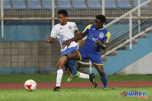 Photo: Presentation College (San Fernando) winger Jordan Riley (left) tries to wriggle from Shiva Boys Hindu College flanker Quinn Rodney during the SSFL Big Four semifinals on 9 December 2016 at the Ato Boldon Stadium in Couva. (Courtesy Chevaughn Christopher/Wired868)