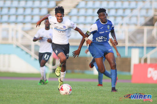 Photo: Presentation College (San Fernando) captain Kareem Riley (right) and Naparima College playmaker Justin Sadoo chase after the ball during the Big Four final at the Ato Boldon Stadium, Couva on 12 December 2016. (Courtesy Chevaughn Christopher/Wired868)