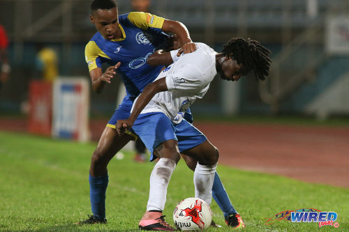 Photo: Presentation College (San Fernando) right back Mylz Barrington (right) holds off Shiva Boys Hindu College winger Ronaldo Edwards during the SSFL Big Four semifinals on 9 December 2016 at the Ato Boldon Stadium in Couva. (Courtesy Chevaughn Christopher/Wired868)