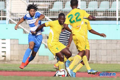 Photo: Presentation College (San Fernando) winger Nion Lammy (left) tries to escape from Signal Hill Secondary defender Nkosei Chance (centre) during the National Intercol Semifinals at the Mannie Ramjohn Stadium on 3 December 2016. (Courtesy Chevaughn Christopher/Wired868)