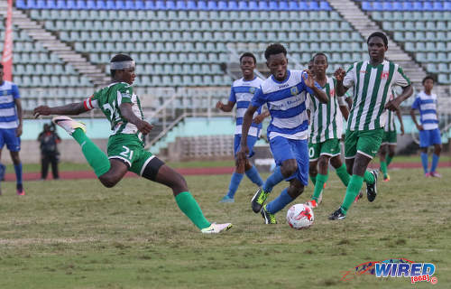 Photo: San Juan Secondary stand-in captain Kyle Thomas (left) prepares to clear the ball from a Presentation College (San Fernando) player during the 2016 National Intercol final at the Mannie Ramjohn Stadium in Marabella on 2 December 2016. (Courtesy Sean Morrison/Wired868)